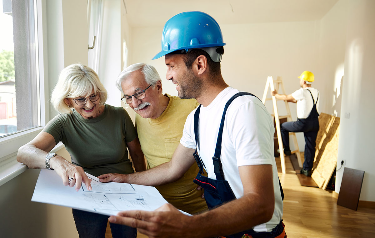 A contractor reviewing plans with a senior couple.