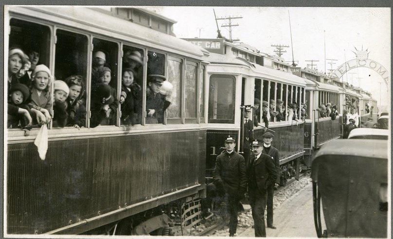 Photo en noir et blanc de personnes dans des tramways.