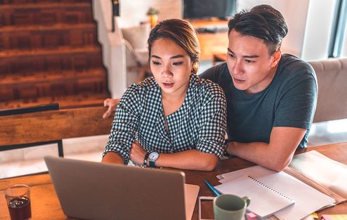 A young couple looking at a laptop