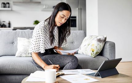 Une femme qui paie ses factures et prend des notes.