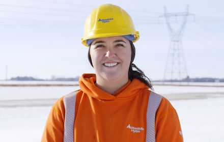 Woman wearing a hard hat at a job site.