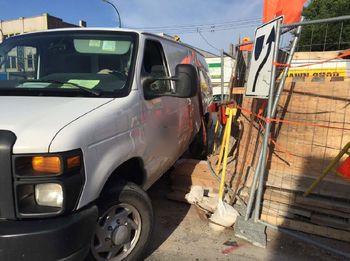 White van sits on construction materials in job site.