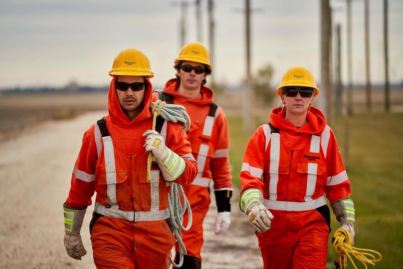 Techniciens au montage de lignes électriques