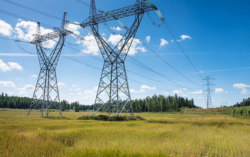Lignes hydroélectriques sous un ciel bleu.