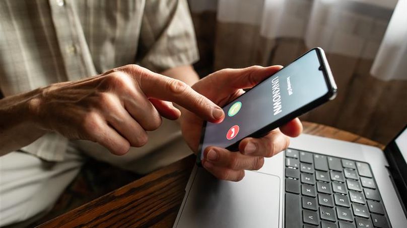 A person tapping a phone that reads: unknown number