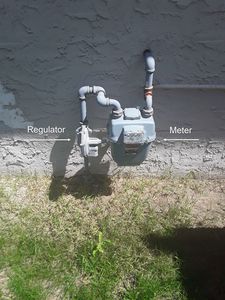 Natural gas meter and regulator with labels.