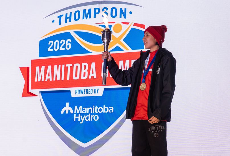 A torch bearer holds the Games torch onstage during opening ceremonies.
