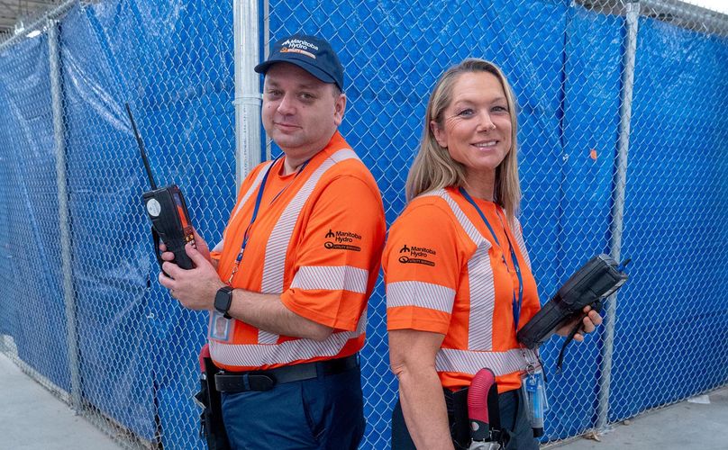 A man and woman pose in new high visibility orange t-shirts.