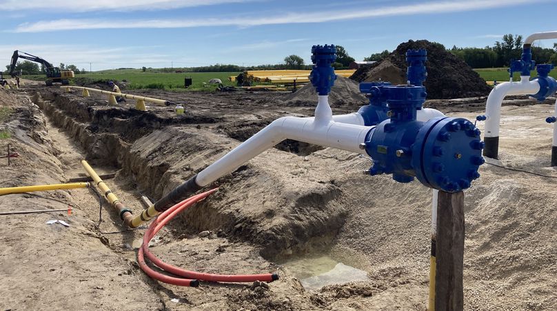 Canalisation de gaz naturel partiellement posée dans une tranchée.