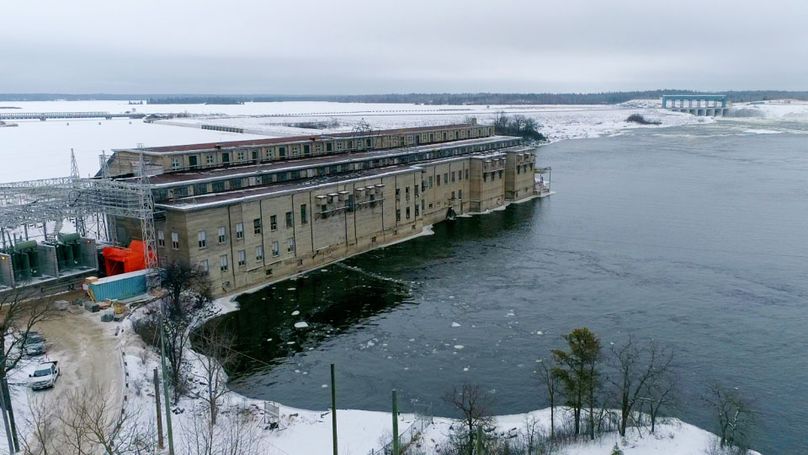 A hydroelectric generating station in a snowy, winter landscape.