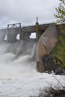 Water pours through spillway gates like a waterfall, at a height that is much higher than normal.
