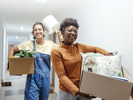 Un couple transportant des boîtes à l’intérieur d’une maison
