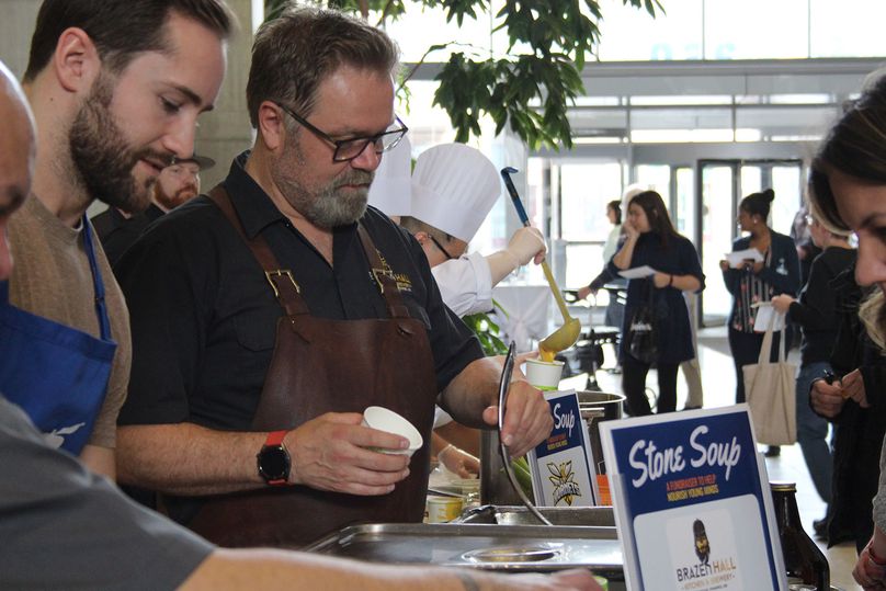 Chefs ladle out soup into cups in the Manitoba Hydro Place gallery.
