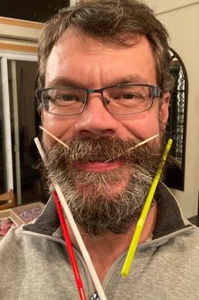Tom Tonner avec une barbe pleine de pailles et de cure-dents.