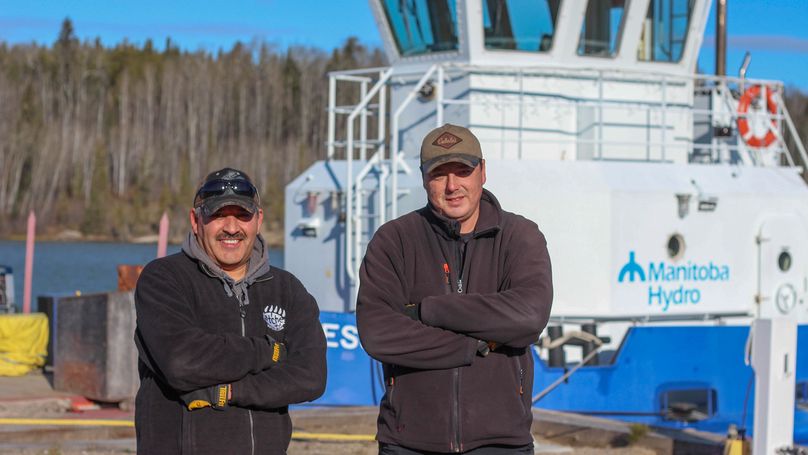 Seafarers Chris Hart and Dennis Bunn stand in front of their vessel, the Jessica Coy