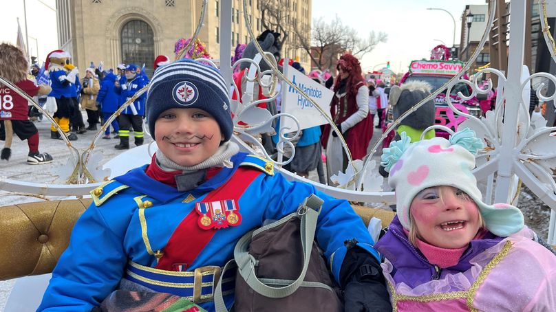 Un jeune garçon en costume de soldat bleu et une jeune fille portant une robe rose.