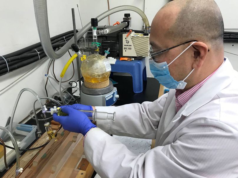 Un technicien de laboratoire prépare un échantillon d’huile dans une seringue.