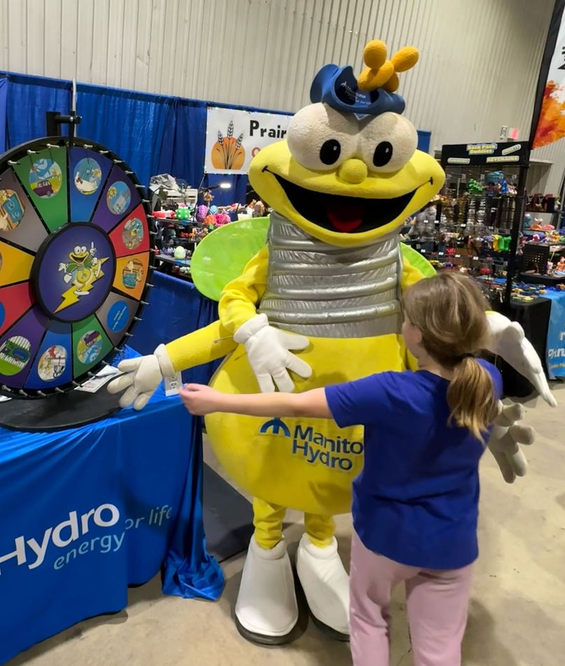 A kid hugs a mascot in a yellow suit.