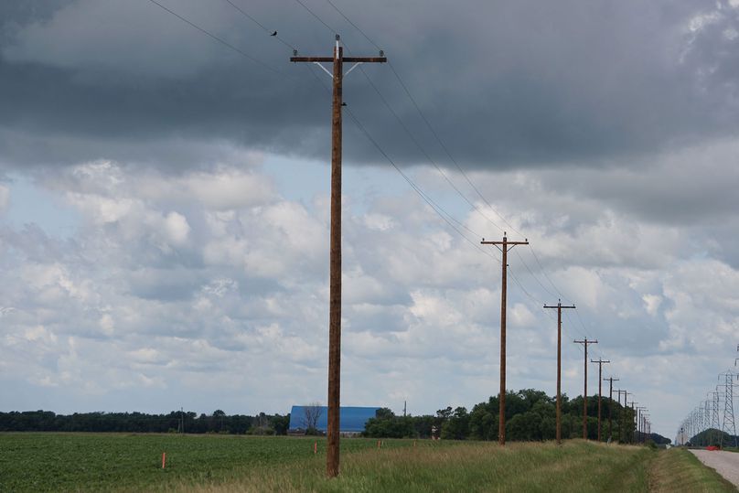 A wood power pole by a country road