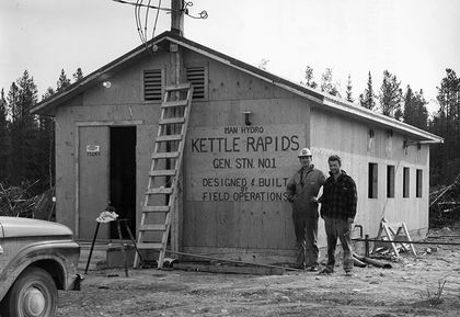 Deux hommes debout à côté du bureau de chantier de construction simple pour les activités de la centrale de Kettle.