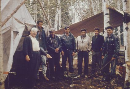 Une outarde de compagnie en laisse dans une forêt boréale avec les travailleurs d’un camp en été, et des tentes.
