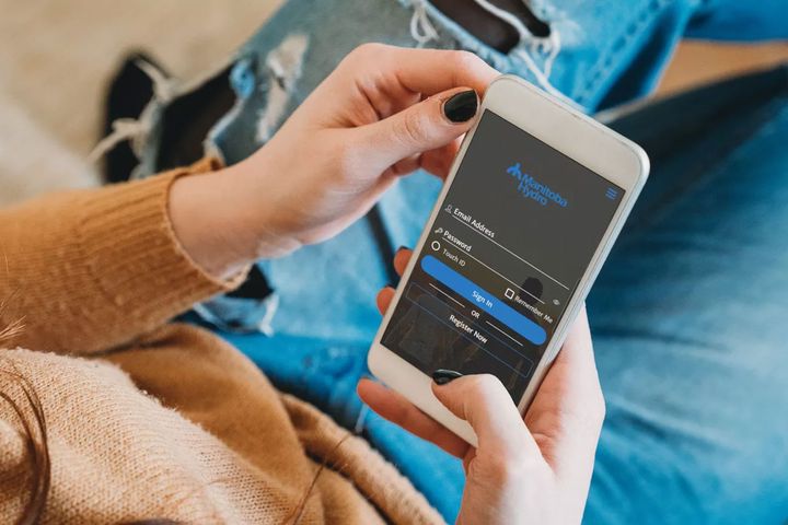 A person logging in to the Manitoba Hydro app on their smart phone.